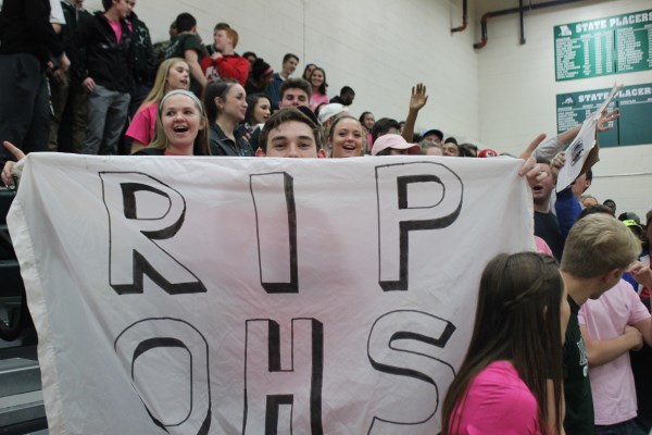 Senior and Green Pit member, Matt Marler, holds up a flag that reads, RIP OHS in the closing seconds of Mehlvilles 74-68 victory over Oakville on  Feb. 25