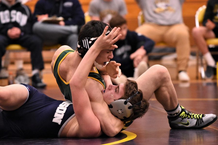 Wrestler pins opponent in head and arm pinning combination.  