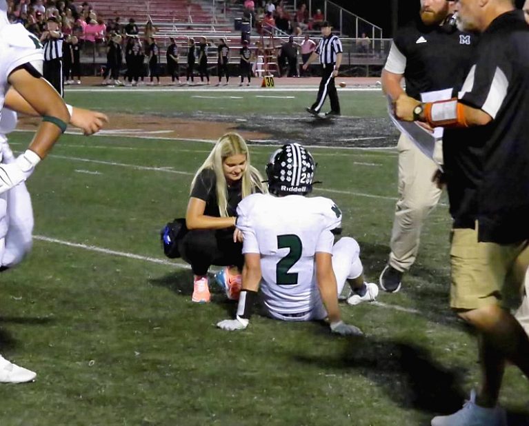 Claire Ditman evaluates Mehlville football player Eric Ohmer after taking a hit during a game against Fox High School. 
