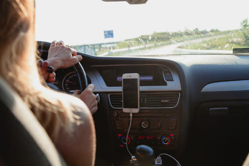 A driver uses a hands-free device in the car. 