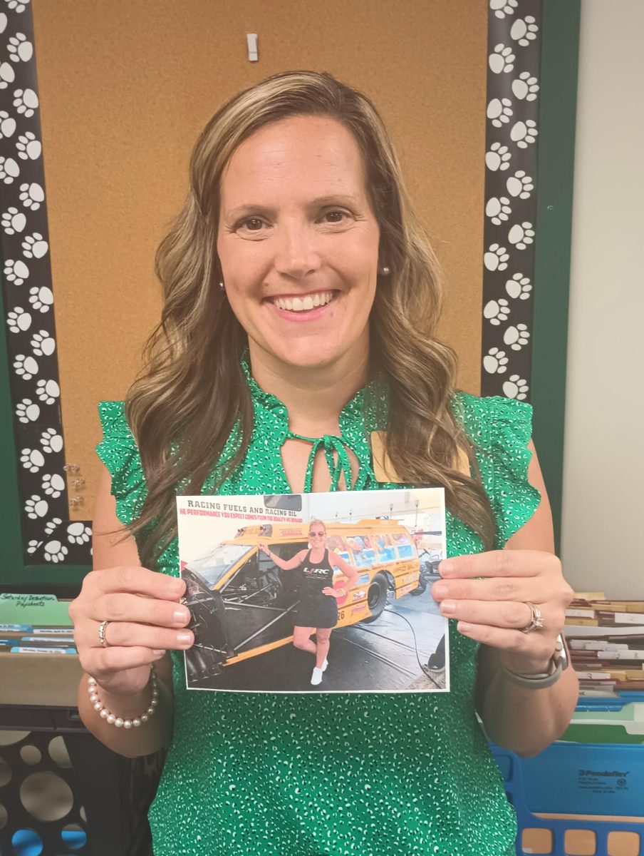 Sarah Gray proudly shows off a converted school bus she took to the racetrack.