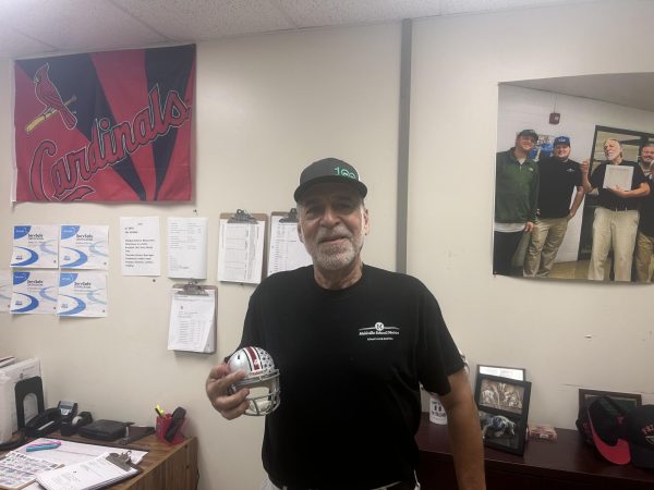 Kitchen Manager Roy Clemens holding Ohio State Helmet.