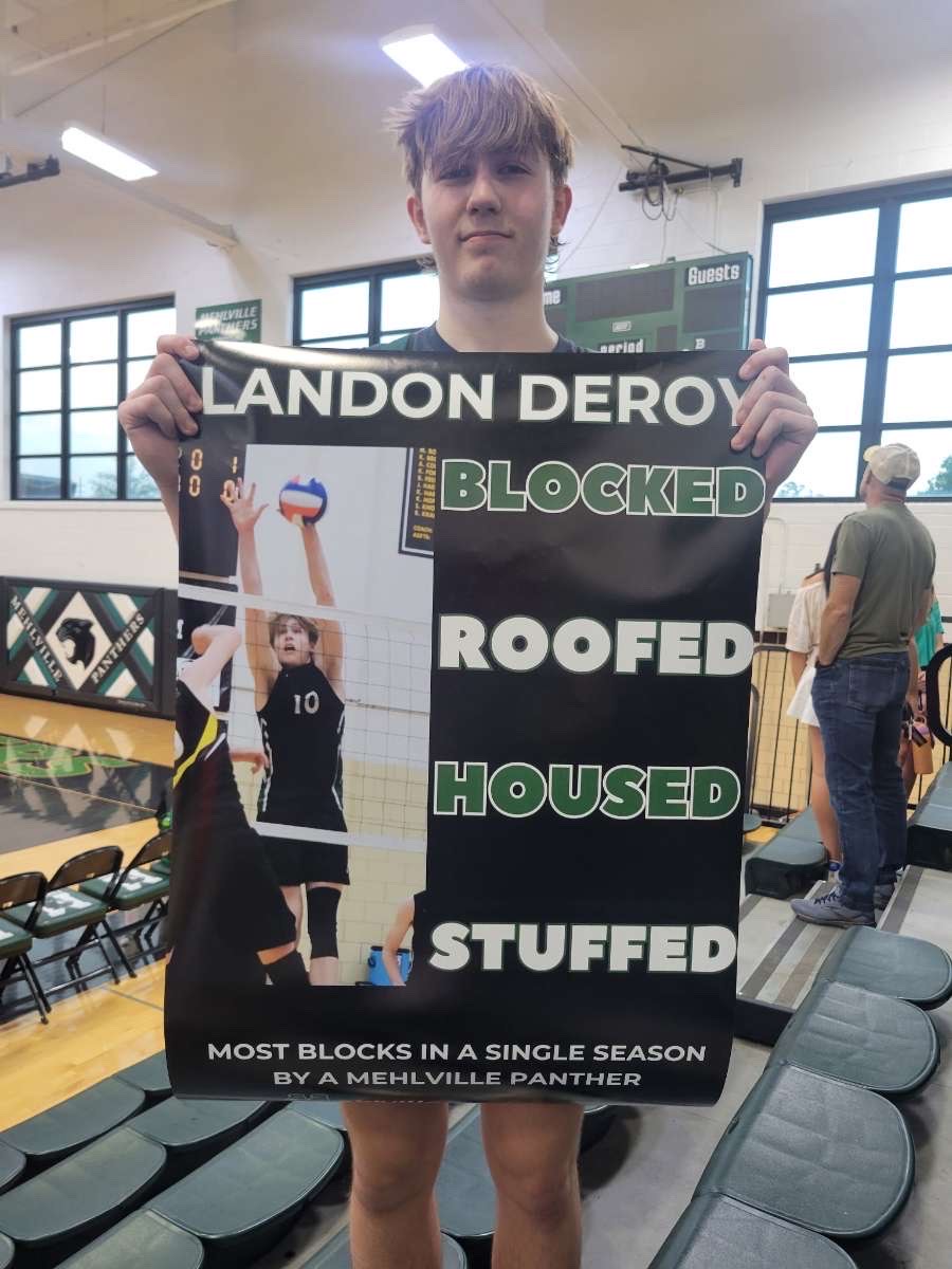 DeRoy holds sign after breaking the single season blocks record at Mehlville High School.